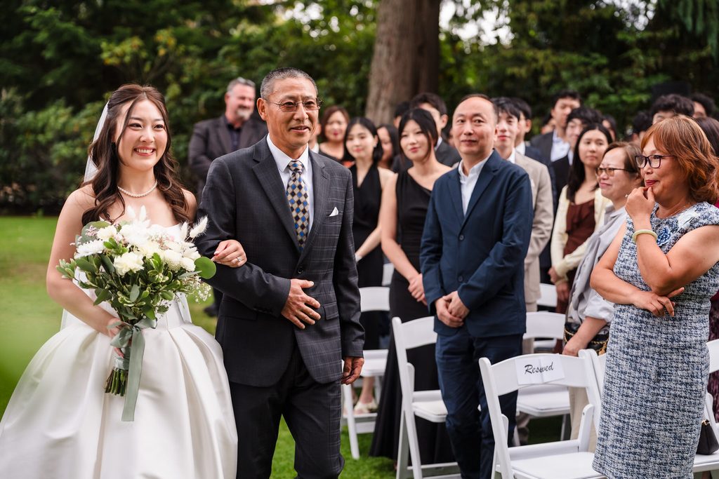 Guests turn to watch as the bride and her father continue down the aisle.