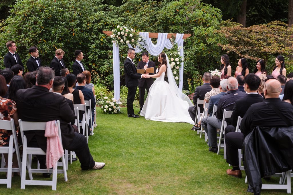 A wide view of the vow reading with guests blurred in the foreground.