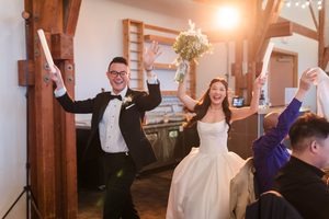 Light flares behind the couple as they dance into their grand entrance holding glow sticks.