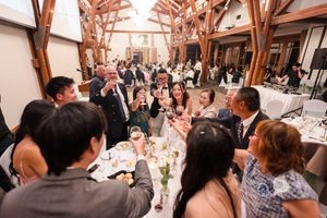 Guests toast the newlyweds with the DJ booth visible in the background.